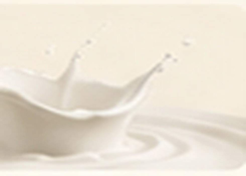 Leche fresca vertiéndose en un vaso sobre fondo claro